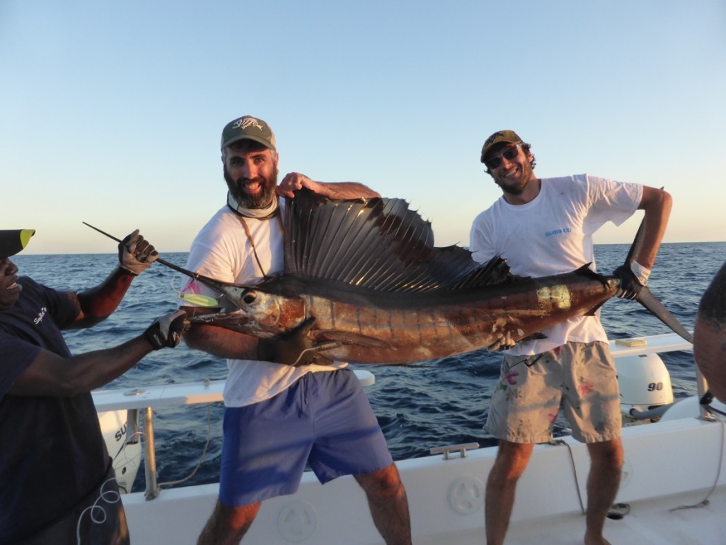 Pescatore in traina a poppa al tramonto
